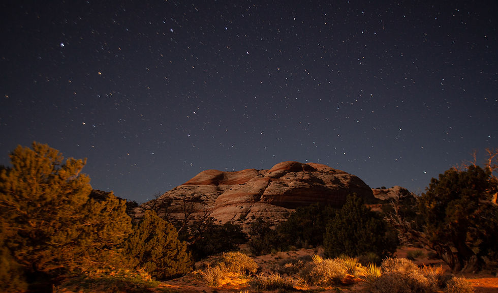 Starry sky over a striped desert landscape.