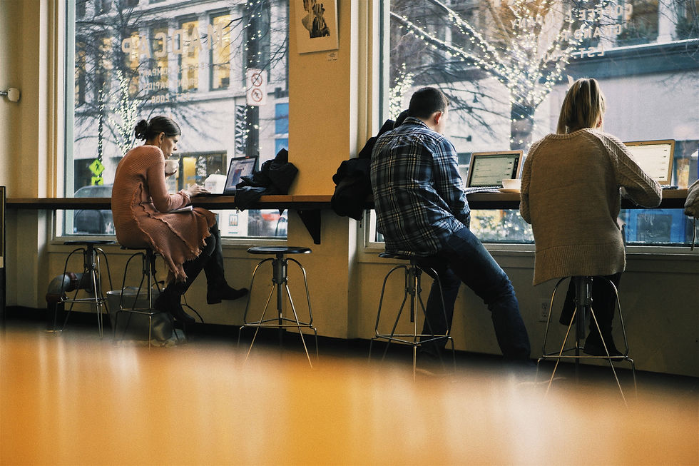 People working on computers in a coffee shop.