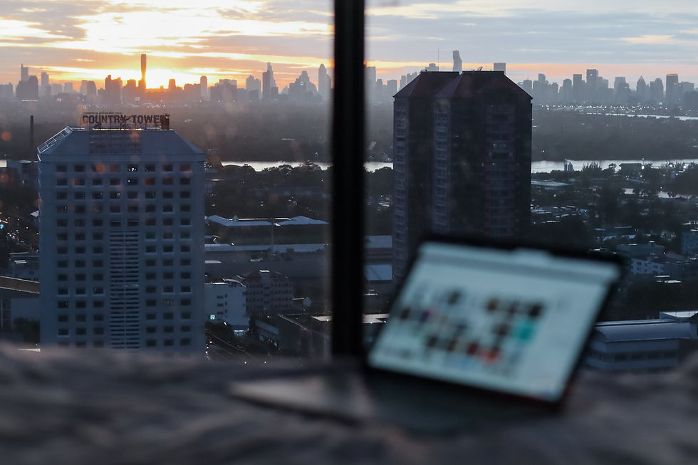 Computer in front of window in busy city.